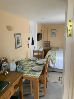 a dining room with a table and a bed at Green Apple Bed and Breakfast in St Ives