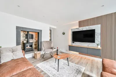 a living room with a couch and a tv at 1 Bake Cottage Serenity - Premium Coastal Retreat in Looe, Cornwall in Looe