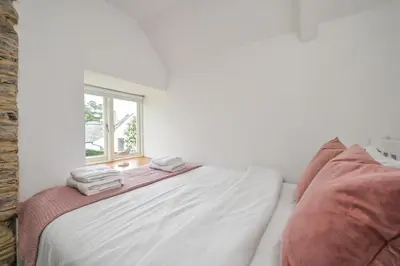 a bedroom with a bed with two towels on it at 1 Bake Cottage Serenity - Premium Coastal Retreat in Looe, Cornwall in Looe