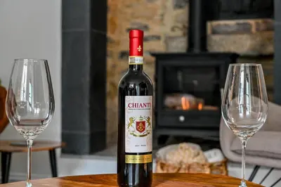 a bottle of wine sitting on a table with two wine glasses at 1 Bake Cottage Serenity - Premium Coastal Retreat in Looe, Cornwall in Looe