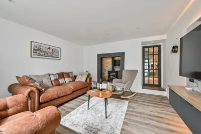 a living room with a couch and a table at 1 Bake Cottage Serenity - Premium Coastal Retreat in Looe, Cornwall in Looe