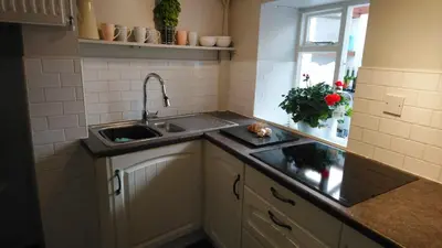 a small kitchen with a sink and a window at The Samphire Cottage in Porthleven