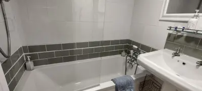 a bathroom with a sink and a bath tub next to a mirror at The Samphire Cottage in Porthleven