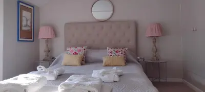 a bedroom with a white bed with towels on it at The Samphire Cottage in Porthleven