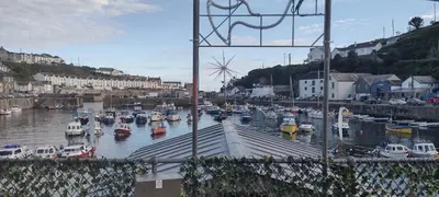 a bunch of boats are docked in a harbor at The Samphire Cottage in Porthleven