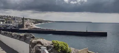a view of a body of water with a pier at The Samphire Cottage in Porthleven