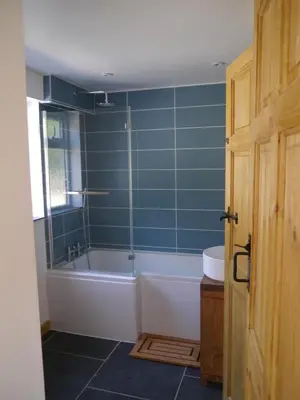 a bathroom with a bath tub and a sink at Morvoren Cottage in Launceston