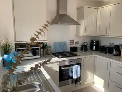 a kitchen with white cabinets and a stove top oven at 2 Boathouse Terrace in Wadebridge