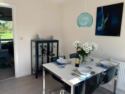 a white table with chairs and a bottle of wine at 2 Boathouse Terrace in Wadebridge