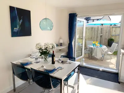 a dining room with a white table and chairs at 2 Boathouse Terrace in Wadebridge