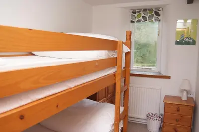 two bunk beds in a room with a window at Dozmary Cottage in Launceston