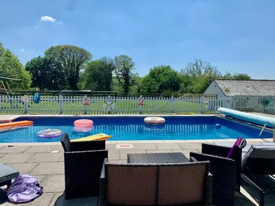 a swimming pool with chairs and frisbees in it at Dozmary Cottage in Launceston