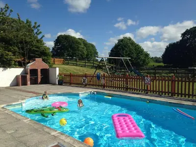a swimming pool with two children playing in it at Dozmary Cottage in Launceston
