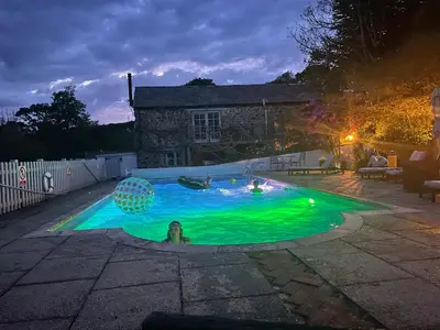 a man in a swimming pool at night at Dozmary Cottage in Launceston