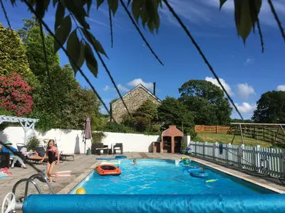 a child playing in a pool in a backyard at Dozmary Cottage in Launceston