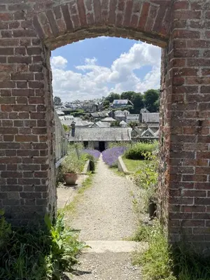 an archway in a brick wall with a garden at 2 Bedrooms overlooking Little Petherick Creek in Little Petherick
