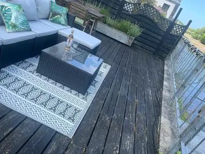 a wooden deck with a table and a couch at 2 Bedrooms overlooking Little Petherick Creek in Little Petherick