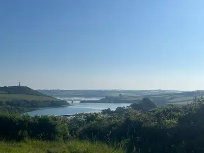 a view of a river with a bridge in the distance at 2 Bedrooms overlooking Little Petherick Creek in Little Petherick
