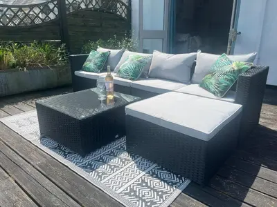 a wicker couch and a table on a patio at 2 Bedrooms overlooking Little Petherick Creek in Little Petherick