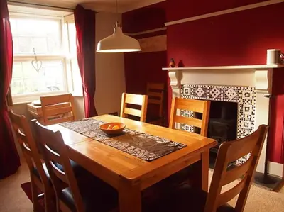 a dining room with a wooden table and a fireplace at Truck House, Luxury accommodation, pet friendly, Probus in Truro