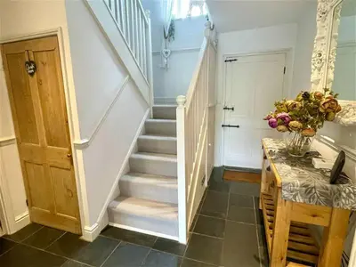 a staircase in a house with a vase of flowers at Truck House, Luxury accommodation, pet friendly, Probus in Truro