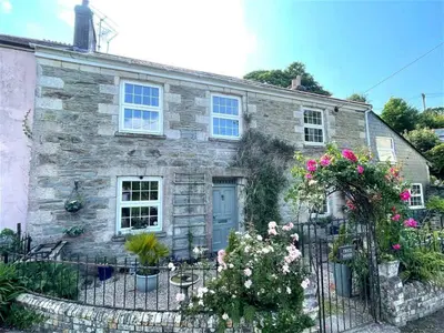 an old stone house with flowers in front of it at Truck House, Luxury accommodation, pet friendly, Probus in Truro