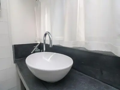 a white bowl sink in a bathroom with a window at An Skyber in Penzance