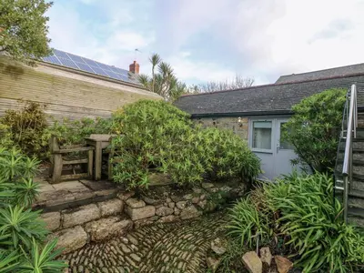 a house with a garden and a building with solar panels at An Skyber in Penzance