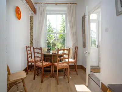 a dining room with a table and chairs and a window at Chapel House in Polruan