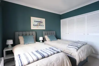 two beds in a bedroom with blue walls at Spectacular Waterfront Views With Parking At 'Mariners Mirror' in Falmouth