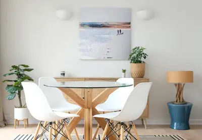 a dining room with a glass table and white chairs at Spectacular Waterfront Views With Parking At 'Mariners Mirror' in Falmouth