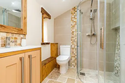 a bathroom with a toilet and a glass shower at Cornwall cottage The Old Piggery in Liskeard