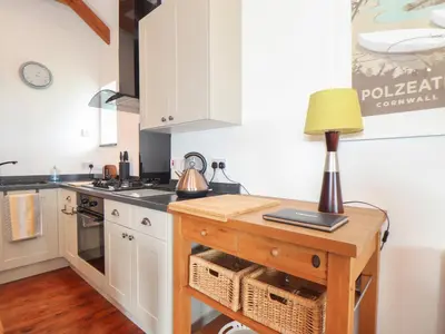 a kitchen with a table with a lamp on it at Long Barn in Penzance