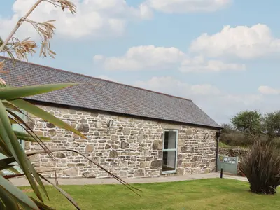 an old stone cottage with a grass yard at Long Barn in Penzance