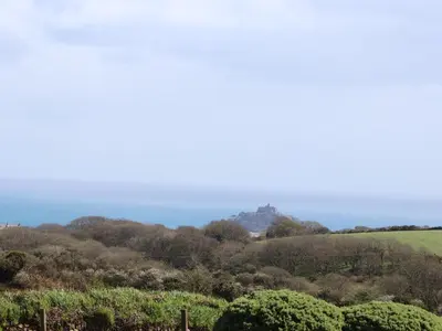 a view of a hill with a castle in the distance at Long Barn in Penzance