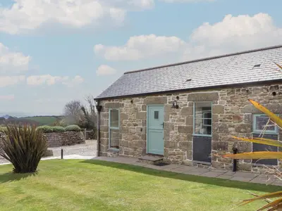 an old stone cottage with a blue door at The Piggery in Penzance