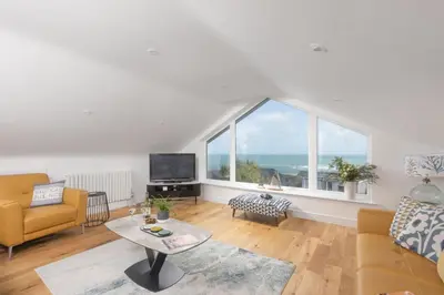 a living room with a table and a large window at Sea views - 500 metres from the sea - Parking in St Ives