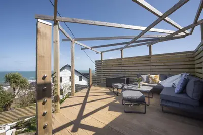 a patio with a couch and a table on a deck at Sea views - 500 metres from the sea - Parking in St Ives