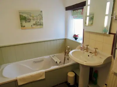 a bathroom with a bath tub and a sink at The Piggery in St Austell