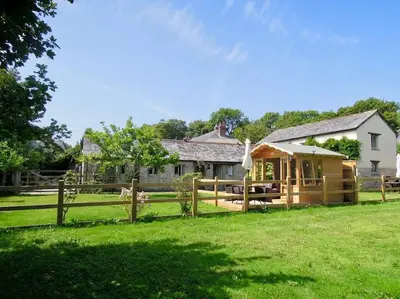 a house with a wooden fence in front of a yard at The Piggery in St Austell