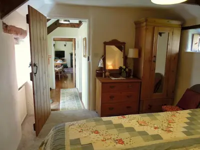 a bedroom with a bed and a dresser and a mirror at The Piggery in St Austell