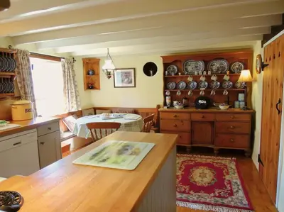 a kitchen with a counter and a table in a room at The Oxen House in St Austell