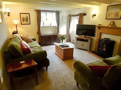 a living room with a couch and a television at The Oxen House in St Austell