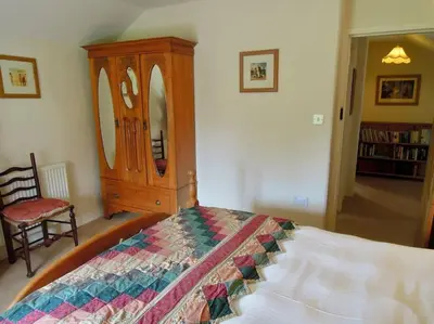 a bedroom with a bed and a wooden dresser at The Oxen House in St Austell