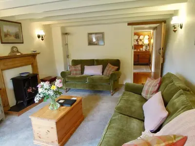 a living room with two green couches and a table at The Oxen House in St Austell