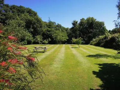a park with a picnic table in the grass at The Stables - Nanjeath in St Austell