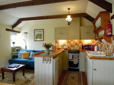 a kitchen with a blue couch in a room at The Stables - Nanjeath in St Austell
