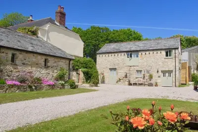 an exterior view of a stone house with flowers at The Granary in St Austell