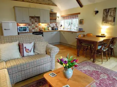 a living room with a couch and a table at The Cider Barn in St Austell