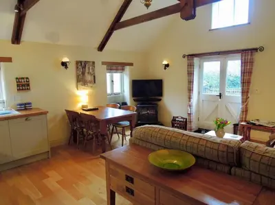 a living room with a couch and a table at The Cider Barn in St Austell
